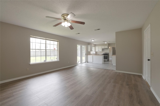 15918 Pinyon Creek Dr, Houston, TX 77095 - unfurnished living room with ceiling fan, wood finished floors, and a textured ceiling