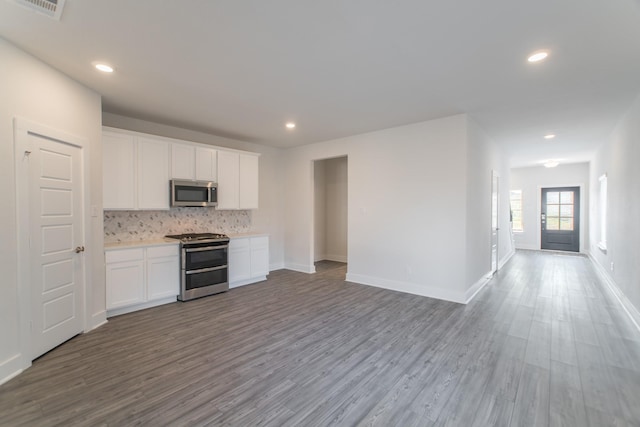 10663 Whitejacket, Conroe, TX 77385 - kitchen with stainless steel appliances, wood finished floors, open floor plan, decorative backsplash, and light countertops