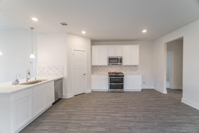 10663 Whitejacket, Conroe, TX 77385 - kitchen featuring stainless steel appliances, a peninsula, backsplash, dark wood finished floors, and recessed lighting