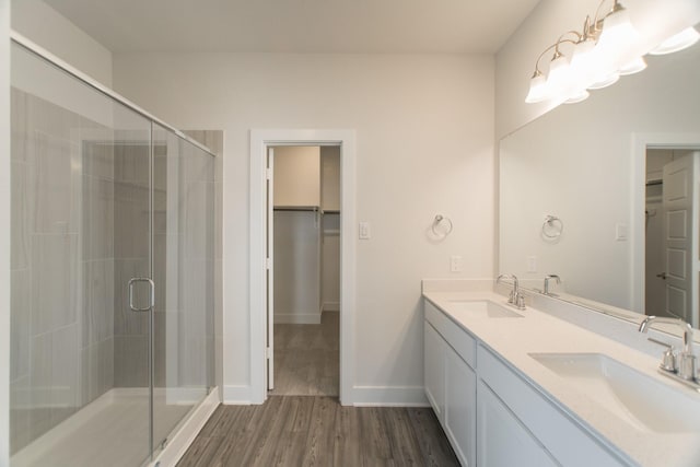 10663 Whitejacket, Conroe, TX 77385 - bathroom featuring a shower stall, double vanity, a spacious closet, and wood finished floors