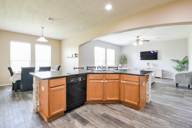 10219 Kentington Oak Dr, Humble, TX 77396 - kitchen featuring black dishwasher, an island with sink, arched walkways, ceiling fan, and wood finished floors