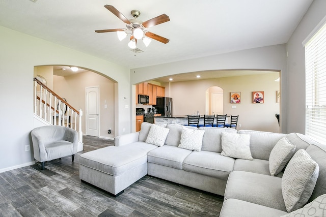10219 Kentington Oak Dr, Humble, TX 77396 - living area with arched walkways, ceiling fan, dark wood finished floors, and stairs