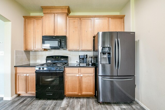 10219 Kentington Oak Dr, Humble, TX 77396 - kitchen featuring black appliances, wood finished floors, dark countertops, and decorative backsplash