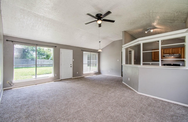 906 Dixie Dr, League City, TX 77573 - unfurnished living room with carpet, vaulted ceiling, ceiling fan, and a textured ceiling