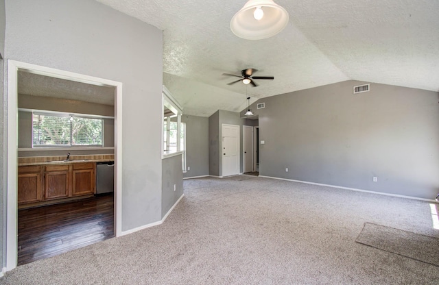 906 Dixie Dr, League City, TX 77573 - unfurnished living room featuring carpet flooring, a textured ceiling, vaulted ceiling, and ceiling fan