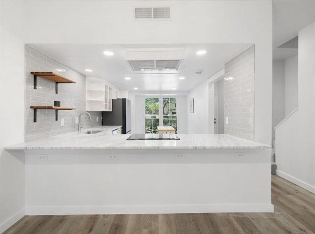 850 Threadneedle St Unit 78, Houston, TX 77079 - kitchen with open shelves, light stone counters, freestanding refrigerator, wood finished floors, and recessed lighting