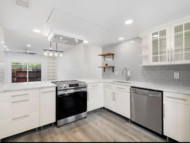 850 Threadneedle St Unit 78, Houston, TX 77079 - kitchen with stainless steel appliances, open shelves, light wood-style floors, tasteful backsplash, and light stone counters