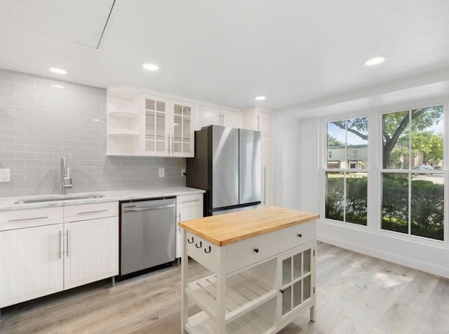850 Threadneedle St Unit 78, Houston, TX 77079 - kitchen featuring appliances with stainless steel finishes, butcher block countertops, open shelves, white cabinets, and decorative backsplash