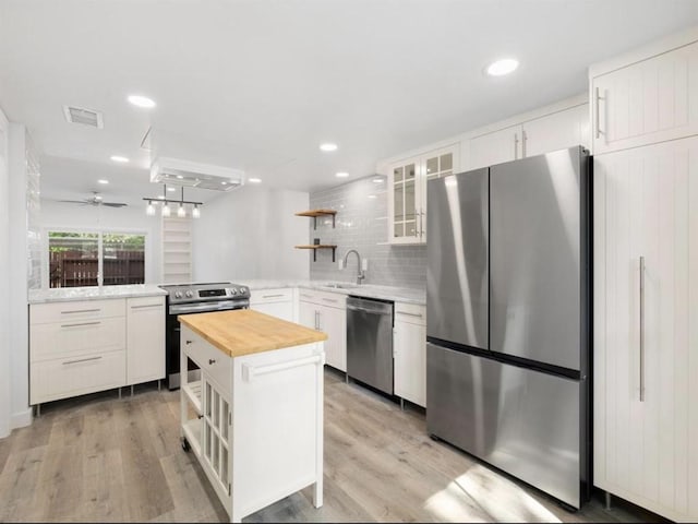 850 Threadneedle St Unit 78, Houston, TX 77079 - kitchen featuring stainless steel appliances, open shelves, butcher block counters, light wood-type flooring, and recessed lighting