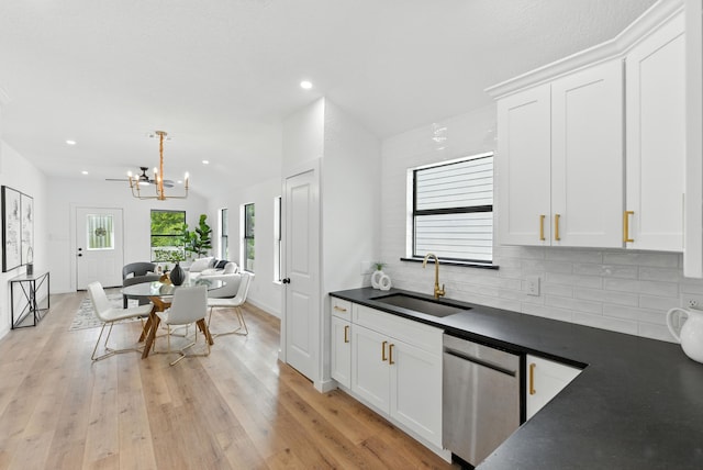 1311 E 35th St, Houston, TX 77022 - kitchen with dark countertops, stainless steel dishwasher, backsplash, white cabinets, and recessed lighting