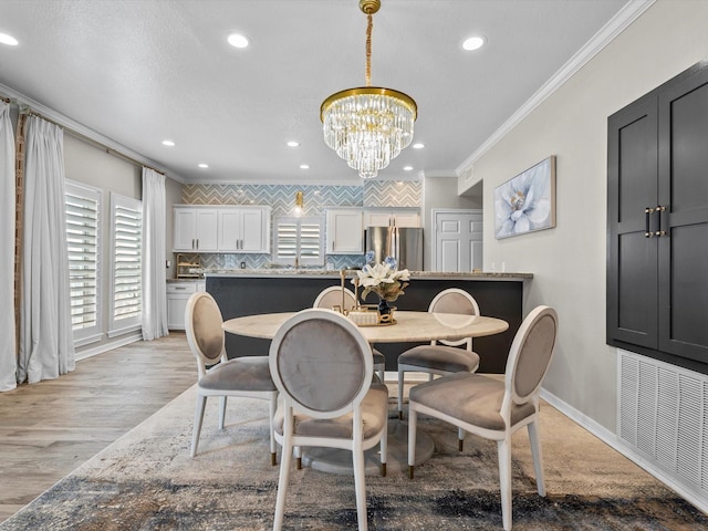 441 Jeanie Lynne Cir, Galveston, TX 77554 - dining space featuring ornamental molding, a chandelier, recessed lighting, and light wood finished floors