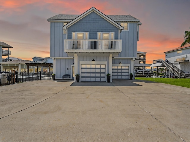 441 Jeanie Lynne Cir, Galveston, TX 77554 - view of front facade with board and batten siding, a balcony, a garage, and concrete driveway
