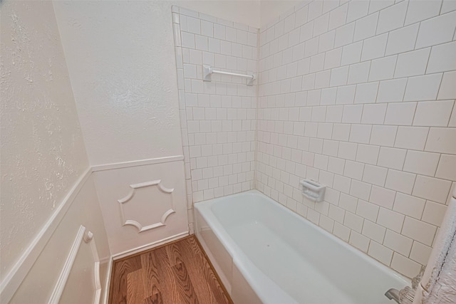 12633 Memorial Dr Unit 250, Houston, TX 77024 - bathroom with wood finished floors, a wainscoted wall,  shower combination, and a textured wall