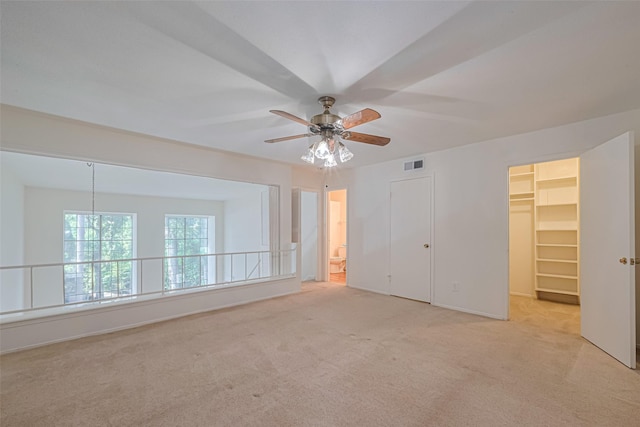 12633 Memorial Dr Unit 250, Houston, TX 77024 - unfurnished bedroom with light carpet, a walk in closet, a closet, a ceiling fan, and ensuite bath