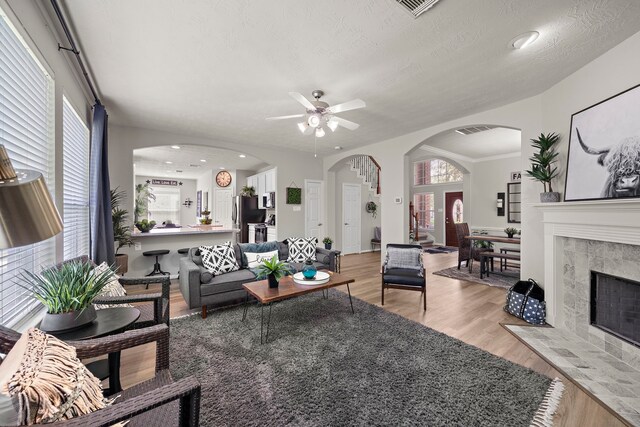 15026 Grape Orchard Ct, Cypress, TX 77433 - living area featuring a ceiling fan, light wood finished floors, arched walkways, a tile fireplace, and recessed lighting