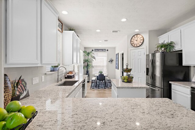 15026 Grape Orchard Ct, Cypress, TX 77433 - kitchen featuring stainless steel appliances, tasteful backsplash, white cabinets, light stone countertops, and recessed lighting