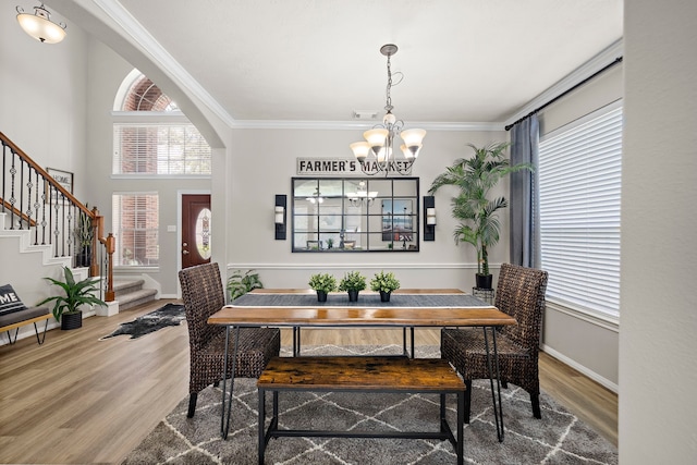 15026 Grape Orchard Ct, Cypress, TX 77433 - dining area with healthy amount of natural light, a chandelier, stairway, wood finished floors, and ornamental molding