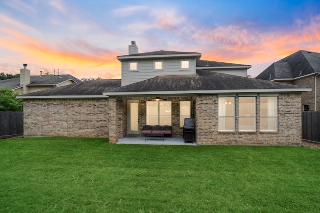 10522 Ginger Gln, Missouri City, TX 77459 - back of house at dusk featuring a patio, brick siding, and a chimney