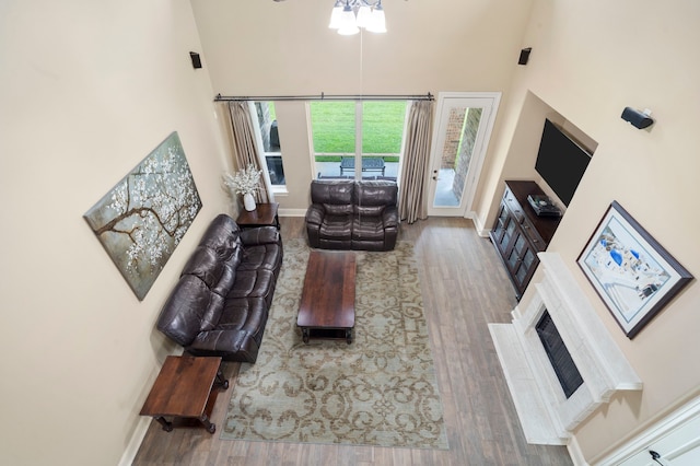 10522 Ginger Gln, Missouri City, TX 77459 - living room featuring a towering ceiling, wood finished floors, a ceiling fan, and a fireplace