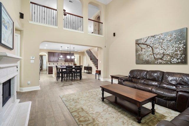 10522 Ginger Gln, Missouri City, TX 77459 - living area featuring arched walkways, a fireplace, light wood finished floors, stairway, and a high ceiling