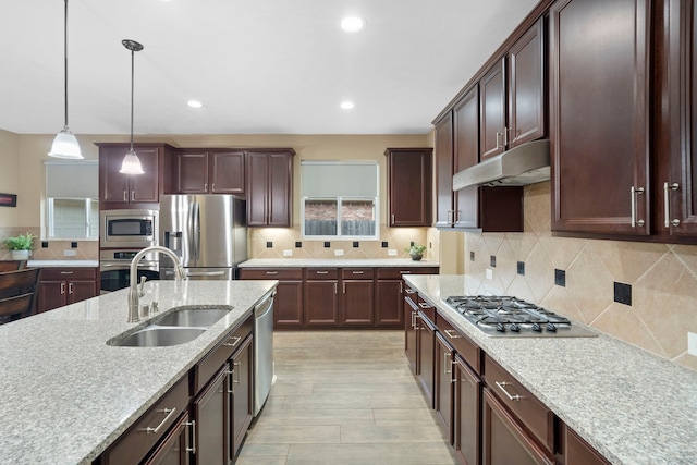 10522 Ginger Gln, Missouri City, TX 77459 - kitchen featuring appliances with stainless steel finishes, under cabinet range hood, decorative light fixtures, decorative backsplash, and recessed lighting