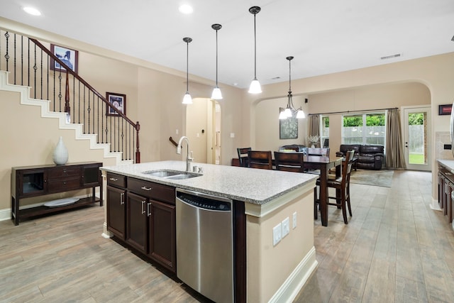 10522 Ginger Gln, Missouri City, TX 77459 - kitchen with dishwasher, arched walkways, light wood finished floors, pendant lighting, and light stone countertops