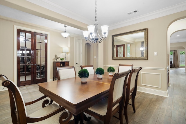 10522 Ginger Gln, Missouri City, TX 77459 - dining space with arched walkways, french doors, wood finished floors, wainscoting, and crown molding
