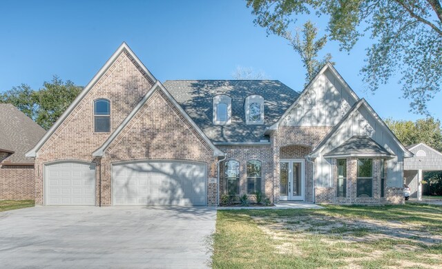 255 W Caldwood Dr, Beaumont, TX 77707 - tudor-style house featuring driveway, an attached garage, brick siding, french doors, and a front yard