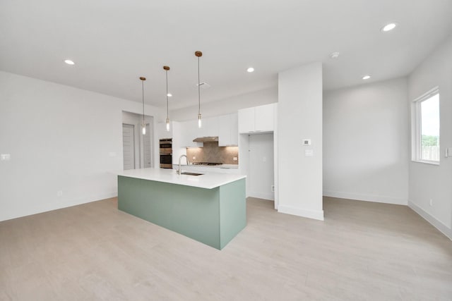 3003A Ventas Dr, Houston, TX 77047 - kitchen featuring white cabinetry, light countertops, a center island with sink, recessed lighting, and decorative backsplash