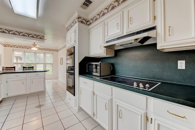 22619 Rockgate Dr, Spring, TX 77373 - kitchen featuring under cabinet range hood, black appliances, dark countertops, light tile patterned floors, and white cabinets