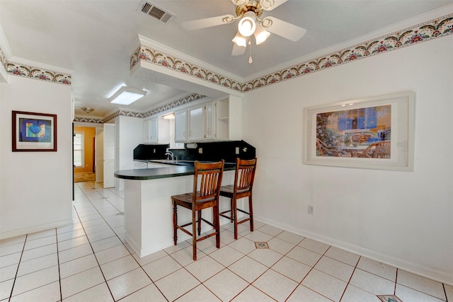 22619 Rockgate Dr, Spring, TX 77373 - kitchen with dark countertops, a peninsula, crown molding, white cabinets, and ceiling fan