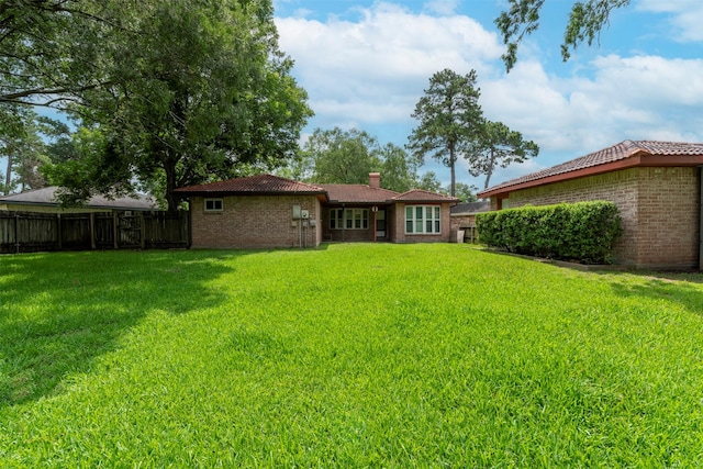 22619 Rockgate Dr, Spring, TX 77373 - back of property featuring a tiled roof, brick siding, and a chimney
