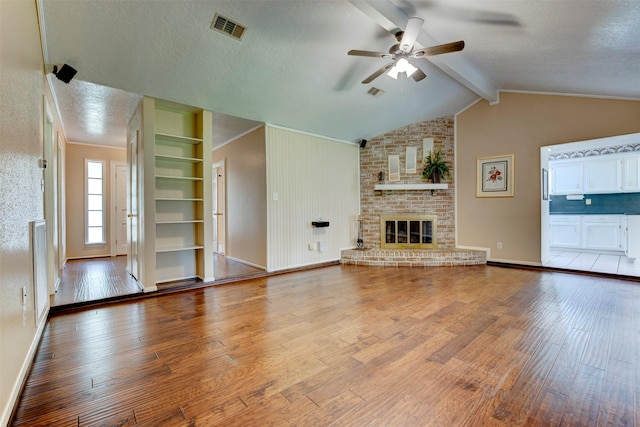 22619 Rockgate Dr, Spring, TX 77373 - unfurnished living room featuring a ceiling fan, wood finished floors, a fireplace, and a textured ceiling
