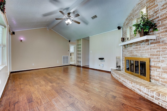 22619 Rockgate Dr, Spring, TX 77373 - unfurnished living room with ceiling fan, wood finished floors, a brick fireplace, and a textured ceiling