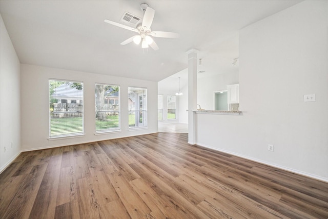 8211 Broken Timber Way, Houston, TX 77095 - unfurnished living room with vaulted ceiling, ceiling fan, wood finished floors, and ornate columns