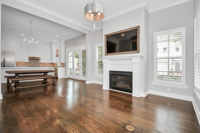 206 Green Blvd, Shenandoah, TX 77384 - living room with a chandelier, a glass covered fireplace, plenty of natural light, and crown molding