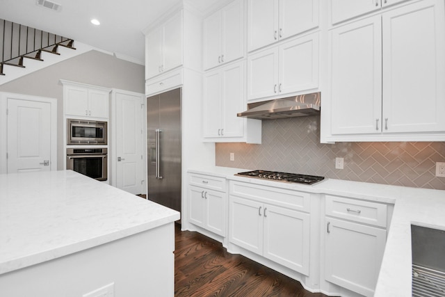 206 Green Blvd, Shenandoah, TX 77384 - kitchen with built in appliances, under cabinet range hood, white cabinetry, tasteful backsplash, and dark wood-style flooring