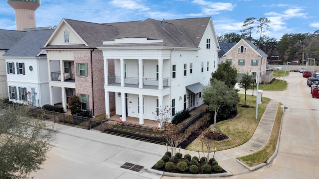 206 Green Blvd, Shenandoah, TX 77384 - view of property exterior featuring a shingled roof, a balcony, and stucco siding