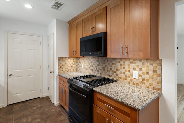 217 Wellwood Ln, Conroe, TX 77304 - kitchen with black appliances, light stone countertops, decorative backsplash, brown cabinets, and recessed lighting