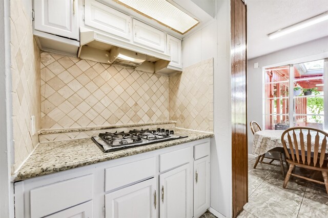 10806 Sagegulf Ln, Houston, TX 77089 - kitchen with white cabinets, backsplash, gas stovetop, and light stone countertops