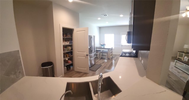 21319 Indigo Ruth Dr, Spring, TX 77379 - kitchen with stainless steel fridge, wood finished floors, gas cooktop, white microwave, and recessed lighting