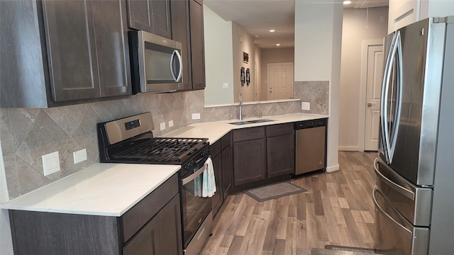 21319 Indigo Ruth Dr, Spring, TX 77379 - kitchen featuring appliances with stainless steel finishes, light wood-style floors, dark brown cabinets, backsplash, and recessed lighting