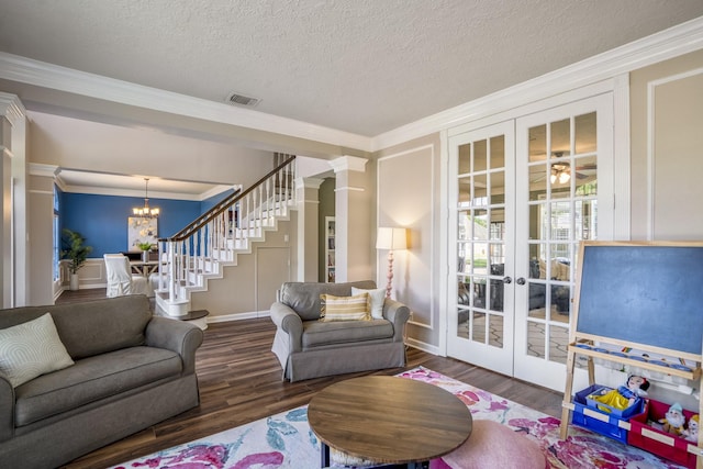 20919 Autumn Redwood Way, Cypress, TX 77433 - living room with french doors, ornamental molding, a chandelier, wood finished floors, and stairway