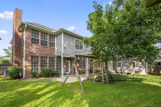 20919 Autumn Redwood Way, Cypress, TX 77433 - back of house with brick siding, a chimney, a patio, and a playground
