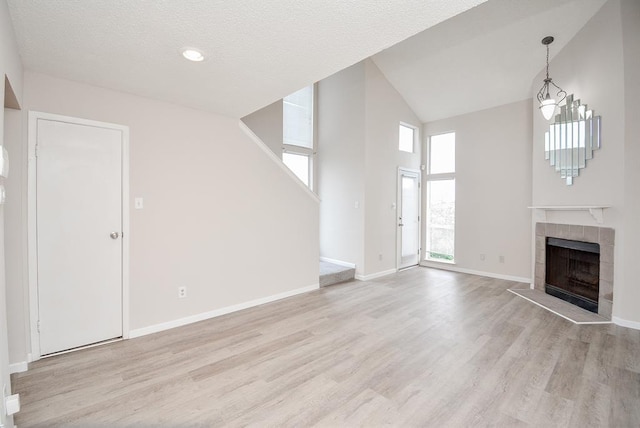 10855 Meadowglen Ln Unit 721, Houston, TX 77042 - unfurnished living room with high vaulted ceiling, a tile fireplace, and light wood-style flooring