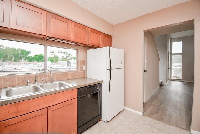 10855 Meadowglen Ln Unit 721, Houston, TX 77042 - kitchen with dishwasher, freestanding refrigerator, light countertops, brown cabinets, and light tile patterned floors