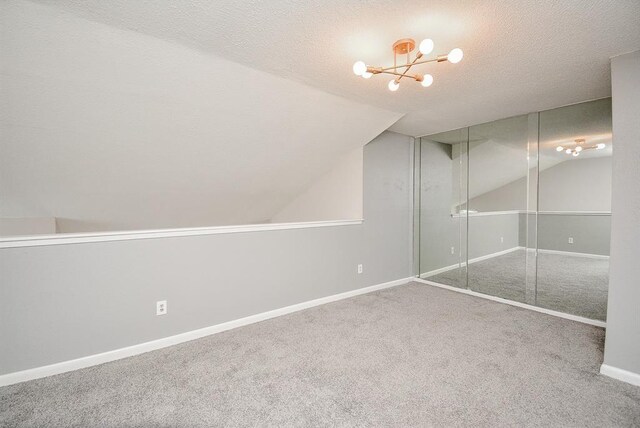 10855 Meadowglen Ln Unit 721, Houston, TX 77042 - unfurnished bedroom with carpet floors, lofted ceiling, a chandelier, a closet, and a textured ceiling