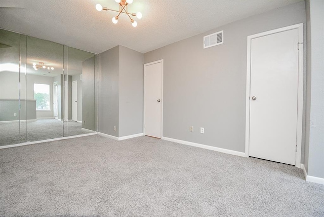 10855 Meadowglen Ln Unit 721, Houston, TX 77042 - unfurnished bedroom with carpet floors, a textured ceiling, and a chandelier