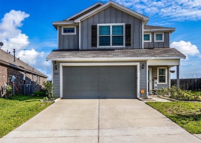 25706 Provender Pl, Katy, TX 77493 - view of front of property with board and batten siding, an attached garage, driveway, and a front yard