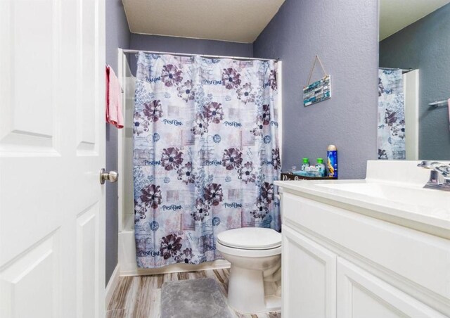 25706 Provender Pl, Katy, TX 77493 - full bathroom with vanity, a textured wall, shower / bath combination with curtain, and wood finished floors